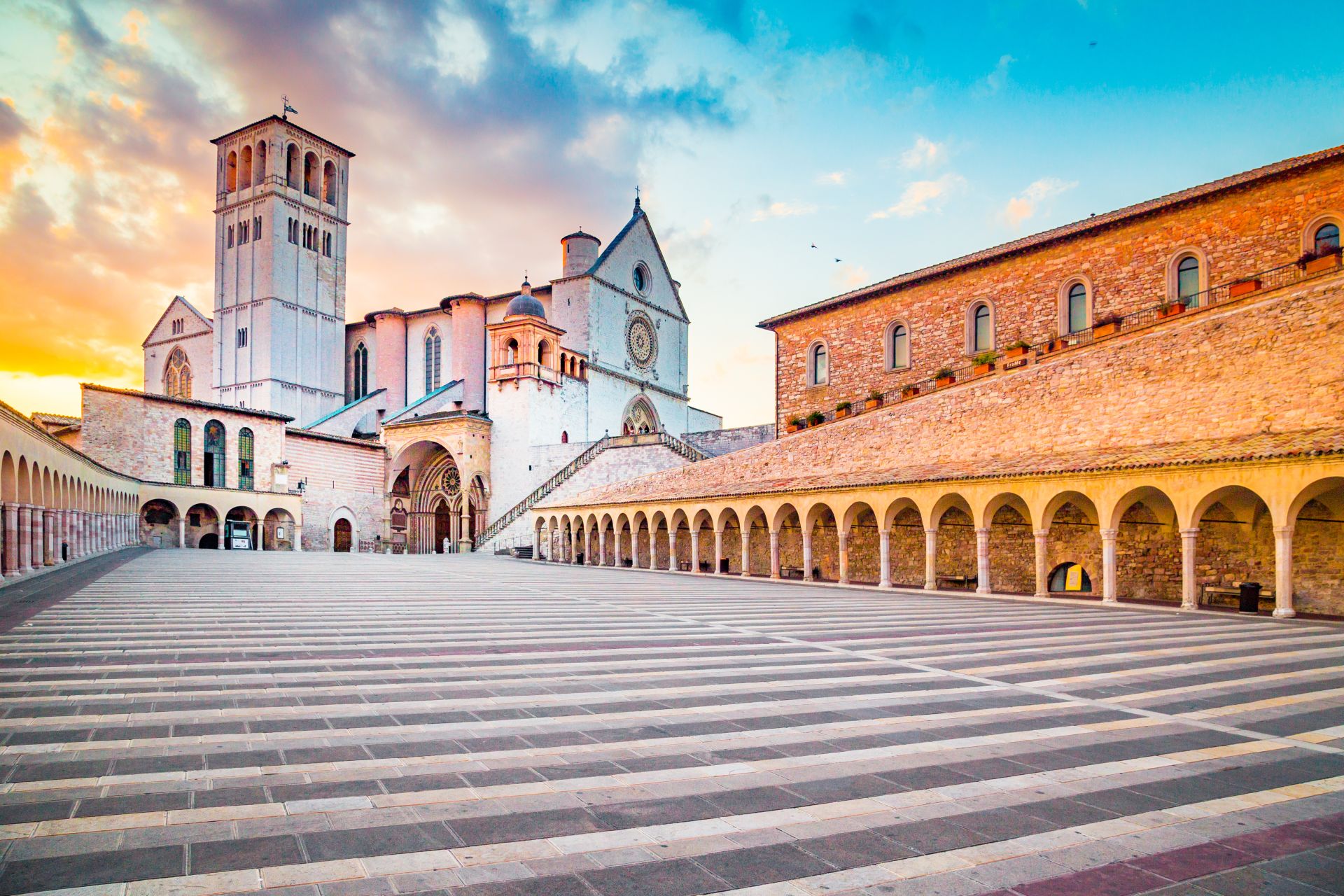 Famous-Basilica-of-St.-Francis-of-Assisi-Basilica-Papale-di-San-Francesco-with-Lower-Plaza-at-sunset-in-Assisi-Umbria-Italy