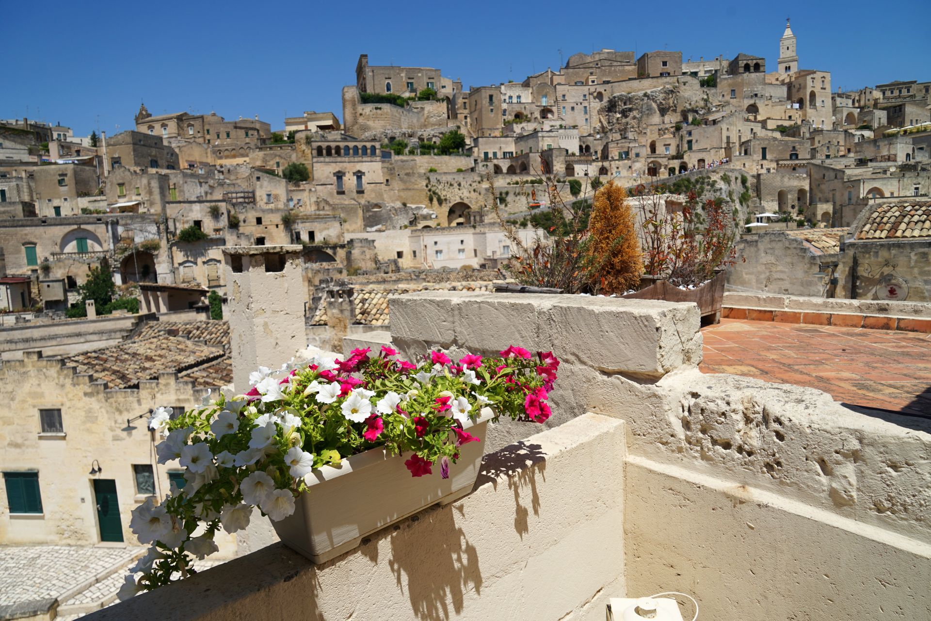 Sassi-di-Matera-historic-site-balcony-with-flowers-view-popular-tourist-travel-place-summer-holiday-concept-Basilicata-Italy